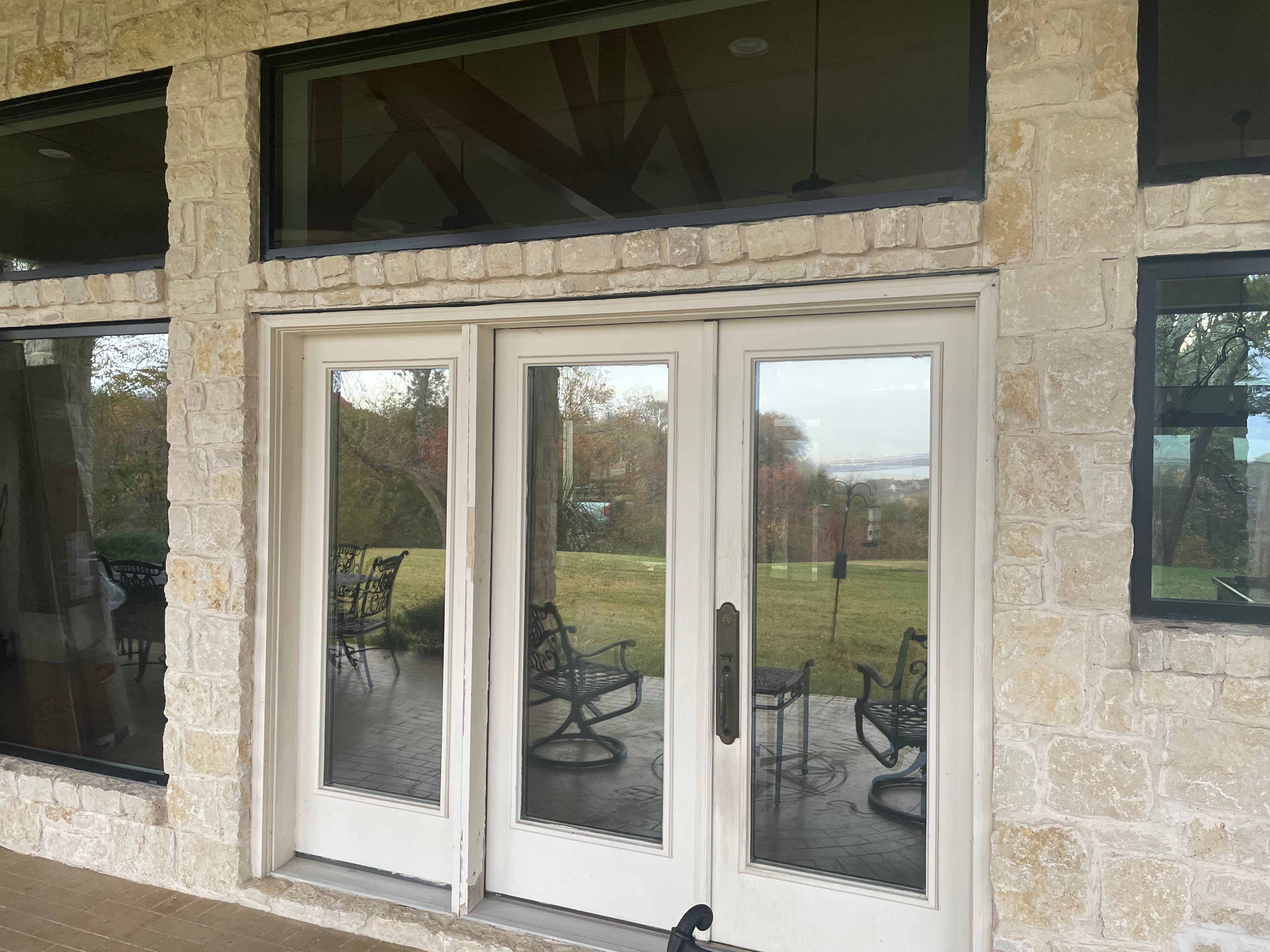 French doors with transom window on limestone and brick exterior
