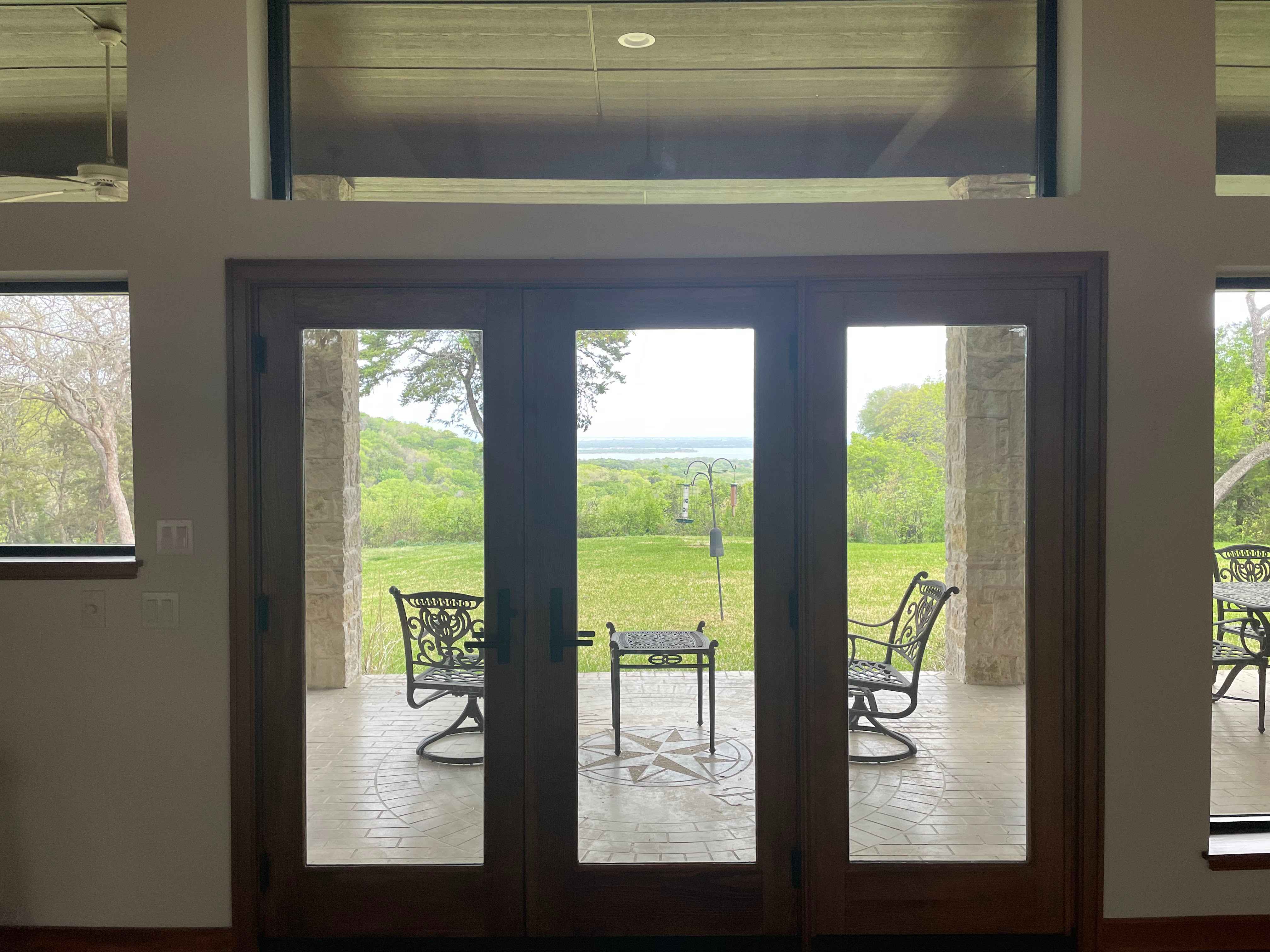 Bronze-framed French doors on whitewashed brick patio area